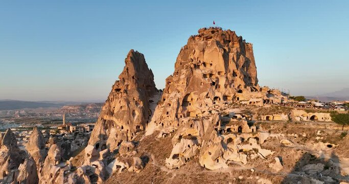 Aerial view of natural rock formations in the sunset, valley with cave houses in Cappadocia, Turkey. Natural landscape city lights at the night.