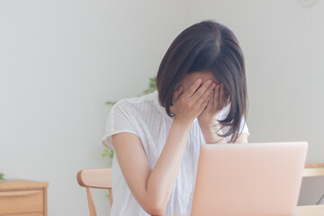 パソコンの前で落ち込む女性