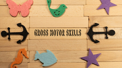 Gross motor skills written on wood patterned surface. Education and child psychology
