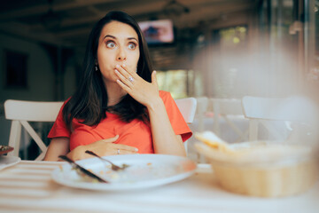 Funny Woman Feeling Full after Eating a Large portion of Food. Restaurant customer regretting...