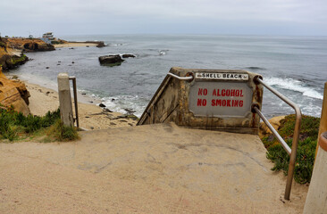 Shell Beach sign by entrance stairs in La Jolla Beach in California. No Alcohol, No Smoking sign. La Jolla Cove.