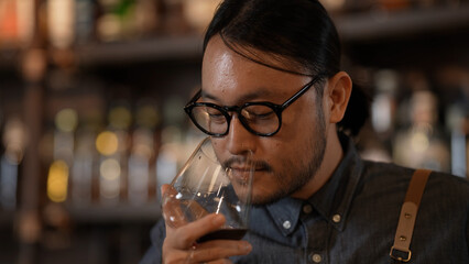Night club concept of 4k Resolution. Asian man tasting wine in a restaurant. A group of specialized clubs that sell alcoholic beverages.