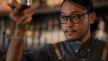 Night club concept of 4k Resolution. Asian man tasting wine in a restaurant. A group of specialized clubs that sell alcoholic beverages.