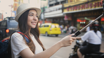 Fototapeta na wymiar Travel concept of 4k Resolution. Asian woman taking pictures on the street while traveling.
