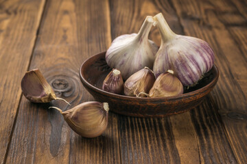 Unpeeled fresh garlic on a dark wooden background.