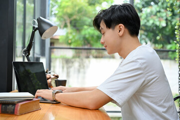 Handsome Asian male startup entrepreneur or office worker working on laptop