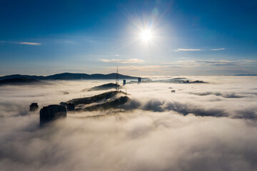 Aerial birds eye view of the Vladivostok lowlands covered in morning sea mist at dawn. Mountain...