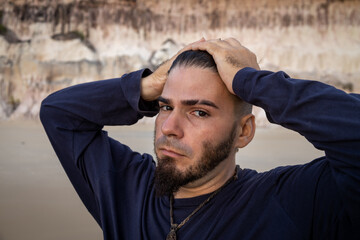 white man in his 30s holding his head with both hands