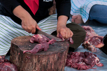 A portrait of Muslims cutting meat on Eid Al Adha by using cutting knife