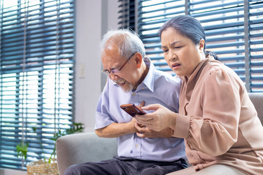 Asian senior man is suffering from heart attack while his wife is searching for paramedic doctor and ambulance rescue team for emergency situation concept - Powered by Adobe