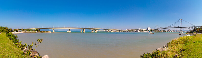 Fototapeta na wymiar mar e céu azul e uma panorâmica das pontes de concreto e da ponte pênsil da cidade de Florianópolis, Santa Catarina, Brasil