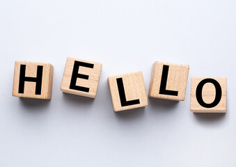 Word HELLO made of wooden cubes on white background, top view