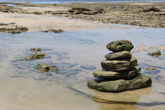 Praia Com água Cristalina E Pedra Zen Que Parece Uma Cabeça De Dinossauro.