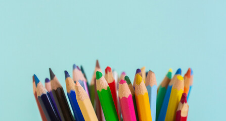 Colorful pencils on blue background banner with copy space close up. Art tools for painting