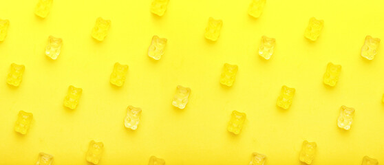 Many sweet jelly bears on yellow background, top view