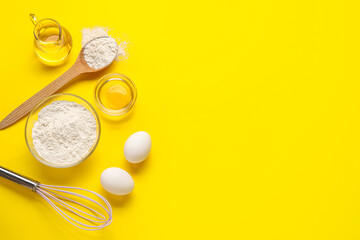 Composition with ingredients for baking and whisk on yellow background