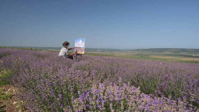 The artist paints a landscape. Oil painting in the open air. Lavender Blooming Field