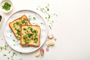 Plate of toasted garlic bread and greens on light background