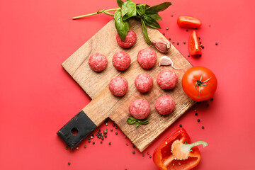 Cutting board with raw meat balls, peppercorns and vegetables on red background