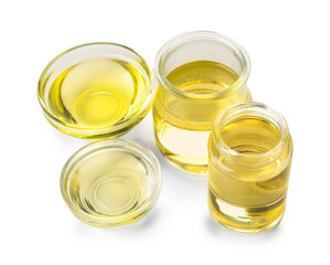 Glass bottles and bowls of sunflower oil on white background