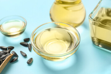 Bowl of sunflower oil on color background, closeup