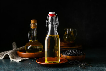 Glass bottle of sunflower oil on dark background, closeup