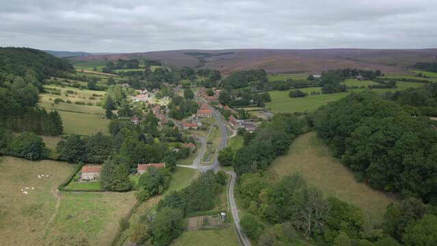 Hutton le Hole North York Moors - approaching from south - aerial drone sequence.
Pretty village with purple heather beyond.