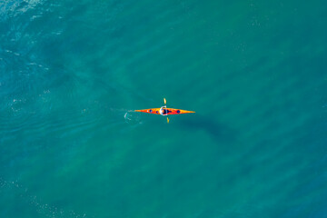 Obraz na płótnie Canvas Red kayak boat blue turquoise water sea, sunny day. Concept banner travel, aerial top view