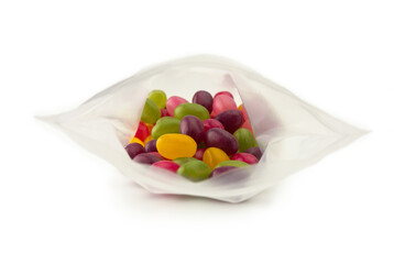 Jelly beans or sugar coated gummy candy inside a plastic bag. Shallow depth of field.