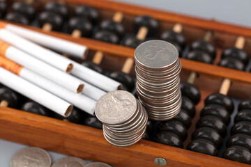 Naklejka premium Coins and cigarettes on a abacus