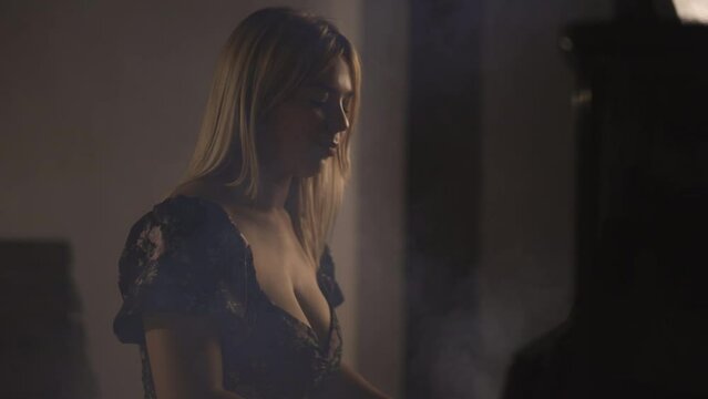 Cinematic Slow Motion Studio Shot of Caucasian Attractive Blond Woman Pianist Musician Playing Piano Instrument, Moody Dark Emotional Tenderness Atmosphere, Smoke in Background