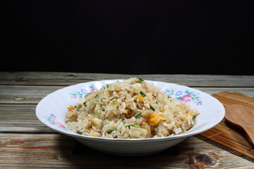 Traditional fried rice mixed with egg and chicken serving on the plate. Famous street food menu in Asia.