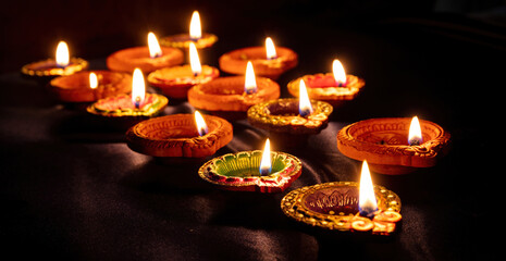 Diwali, Deepavali Hindu festival of lights. Diya lamp lit on black, close up