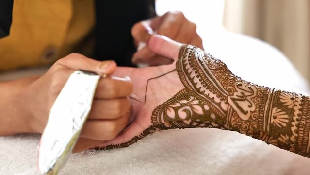 Close-Up Shot Of Mehendi Henna Application Process On Female's Hand.