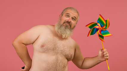 a gray-haired man with a naked torso shows a turntable into the camera. The spinner is painted in...