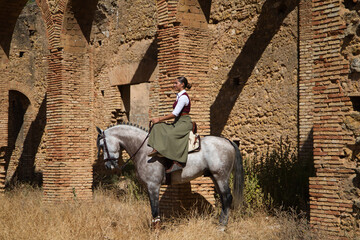 Young and beautiful Spanish woman on a Thoroughbred horse for competition. The woman has gone out...