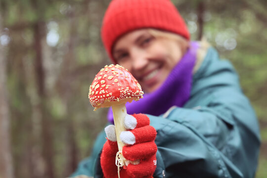person fly agaric, woman holding fly agaric, dangerous poisonous mushroom, eating herbal medicine