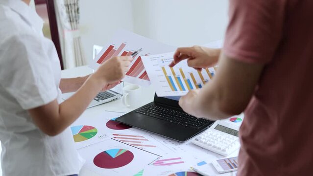 financial team discuss and exchange stock market performance data and charts