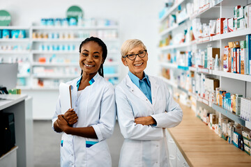 Portret van gelukkige vrouwelijke apothekers in apotheek camera kijken.