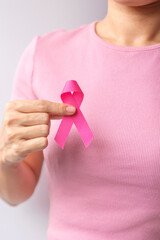 Pink October Breast Cancer Awareness month, woman hand hold pink Ribbon and wear shirt for support...