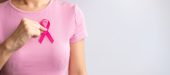 Pink October Breast Cancer Awareness month, woman hand hold pink Ribbon and wear shirt for support people life and illness. National cancer survivors month, Mother and World cancer day concept