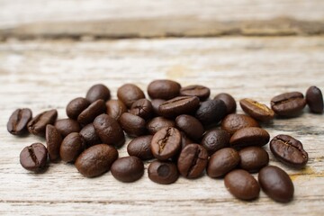 Coffee beans fall on rustic wooden table  Delicious luxury coffee beans and the aroma of morning coffee.