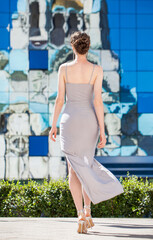 Portrait of a young beautiful woman in a long tight dress