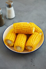 Homemade Steamed Corn on the Cob with Butter on a Plate, side view.