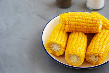 Homemade Steamed Corn on the Cob with Butter on a Plate, side view. Space for text.