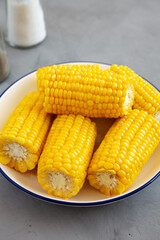 Homemade Steamed Corn on the Cob with Butter on a Plate, side view.