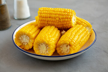 Homemade Steamed Corn on the Cob with Butter on a Plate, side view.