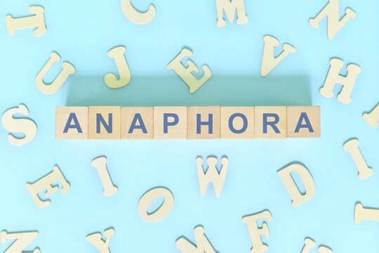 Anaphora figure of speech concept in English grammar class lesson. Wooden blocks typography flat lay in blue background.
