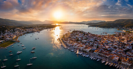 Aerial panorama of the city and harbor of Poros island in the Saronic Gulf, Greece, during a colorful summer sunset - obrazy, fototapety, plakaty