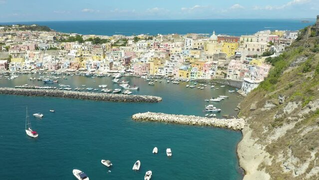 Procida, Italy. Aerial Pan Up Establishing Shot Reveals Picturesque Italian Island Town on Beautiful Summer Day
